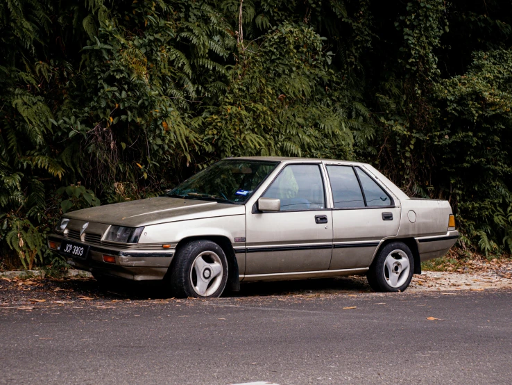 a beige car parked on a road next to trees