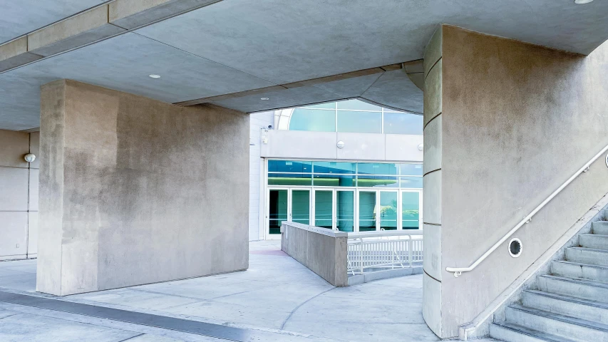 a staircase between two concrete buildings leading to a window