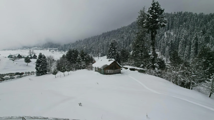 the snow is covering the ground near a small cabin