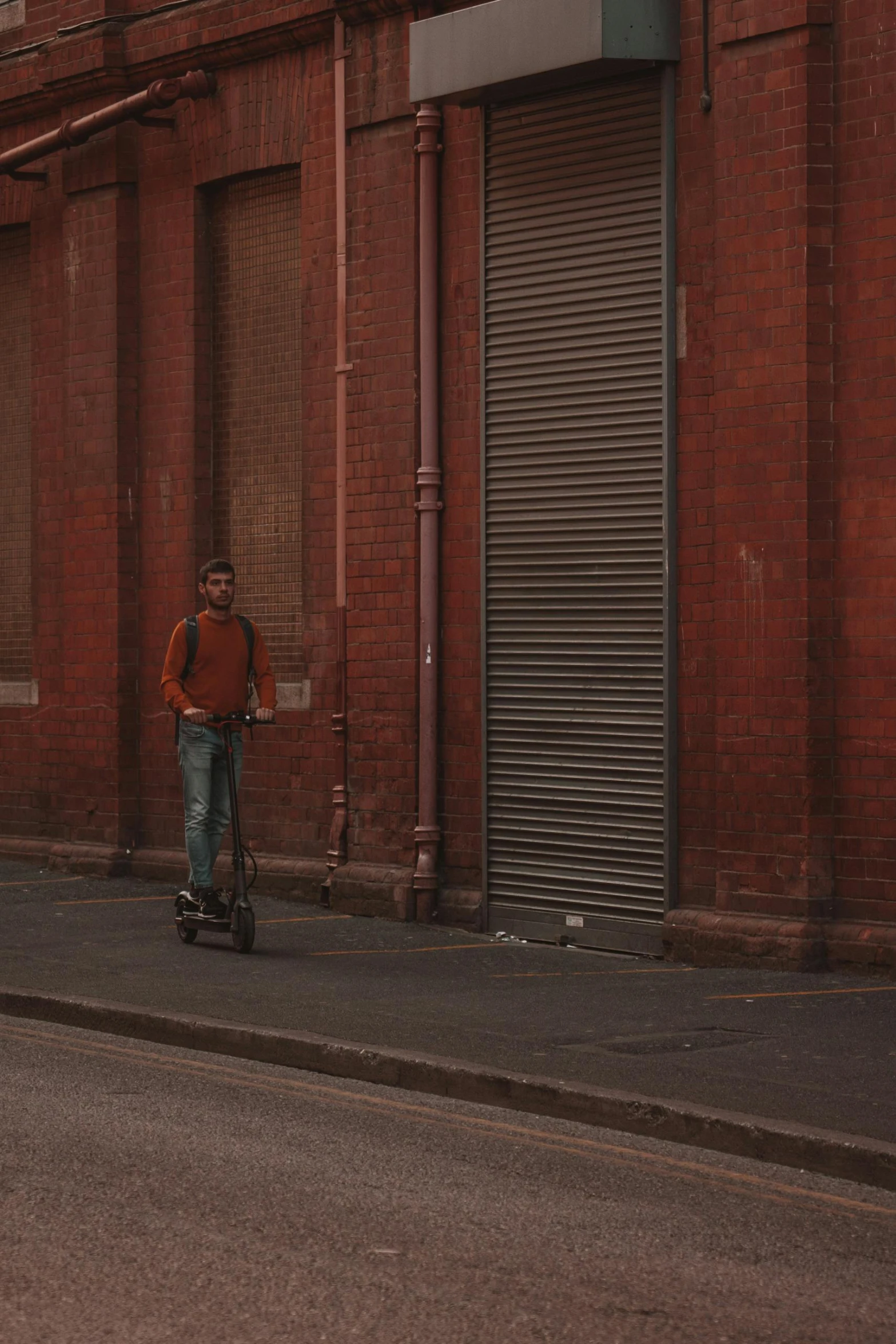 a person on a scooter by a building with a garage