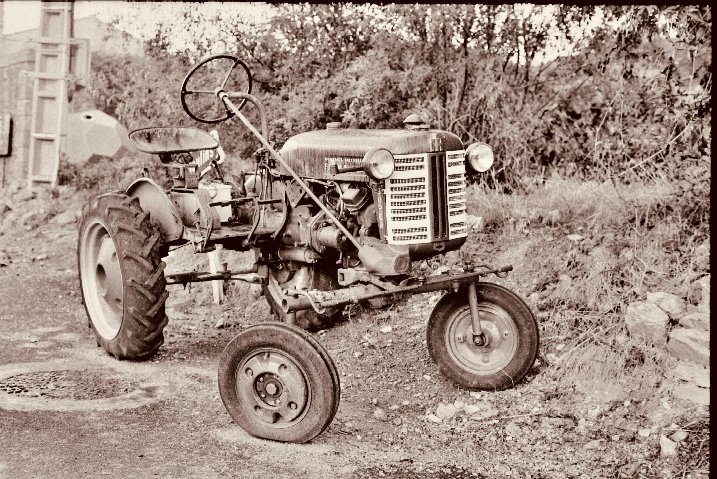 an old po of a tractor sitting on the side of the road