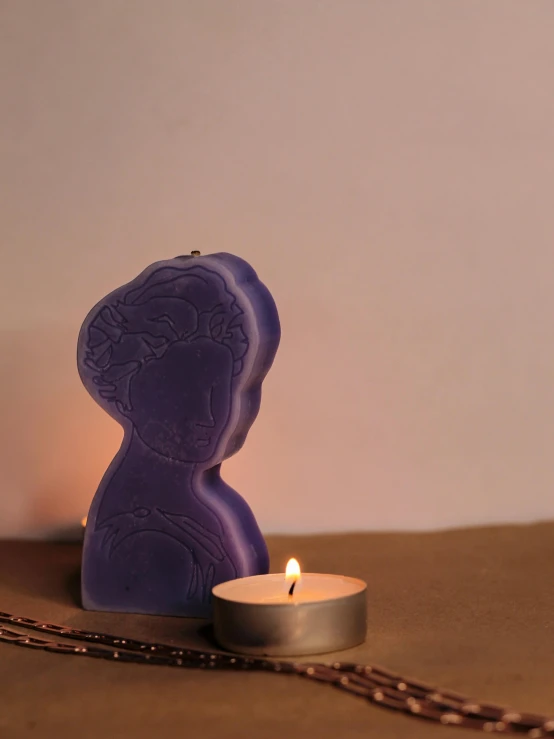 a purple candle sits in front of a chain