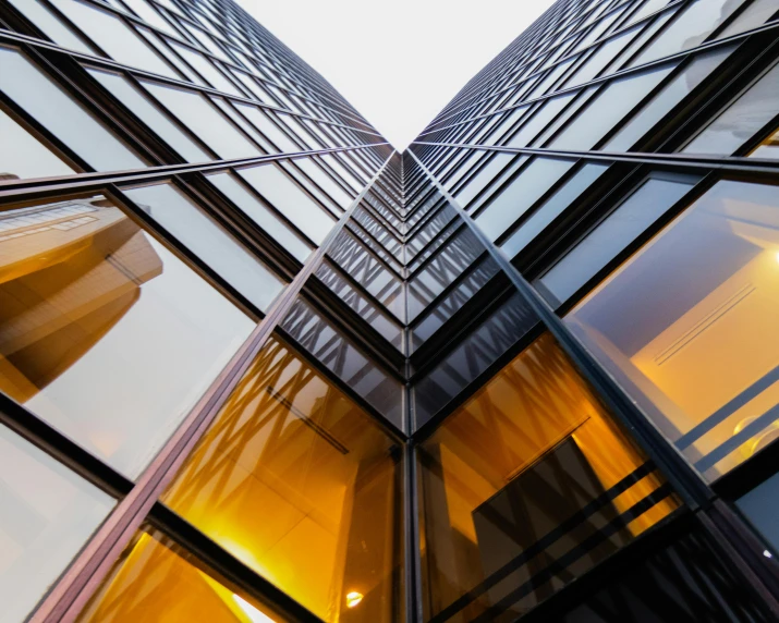 looking up into the glass and steel windows on an office building