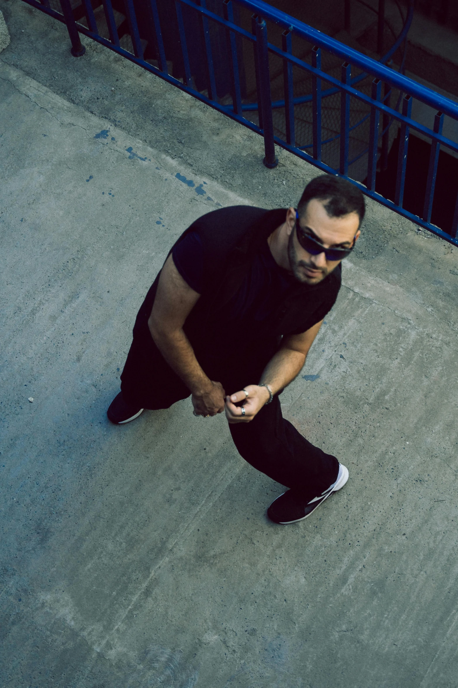 man standing on cement steps wearing black sunglasses