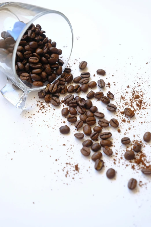 there is coffee spilling from a glass on the table