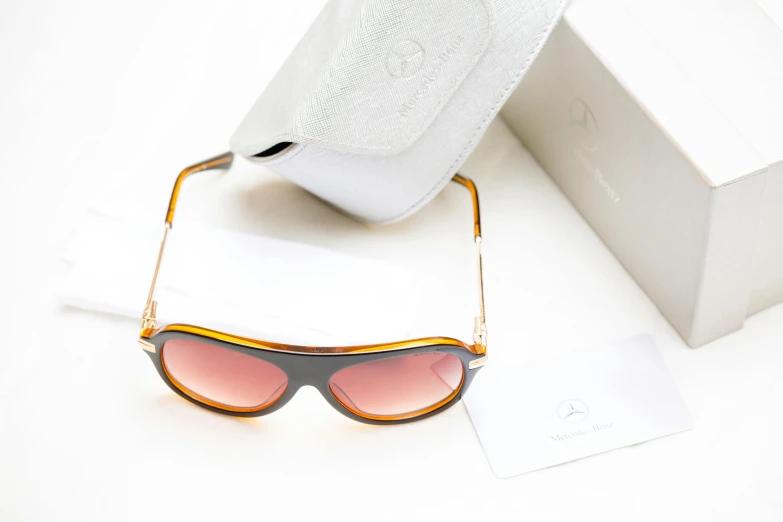 a small box and sunglasses are sitting on a white surface