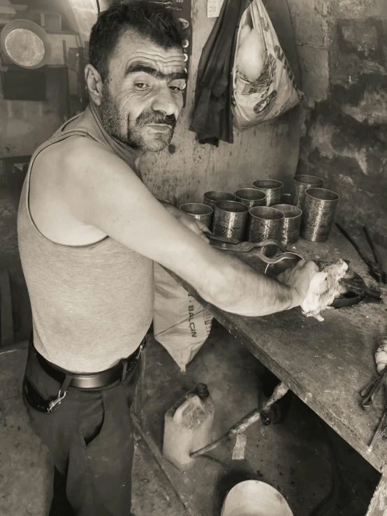 man holding a spoon over an iron pot