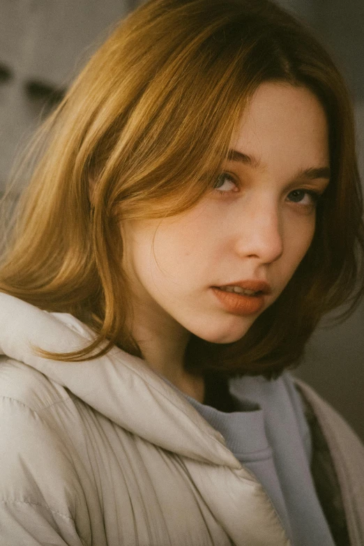 a woman wearing a white hoodie and standing with her face up