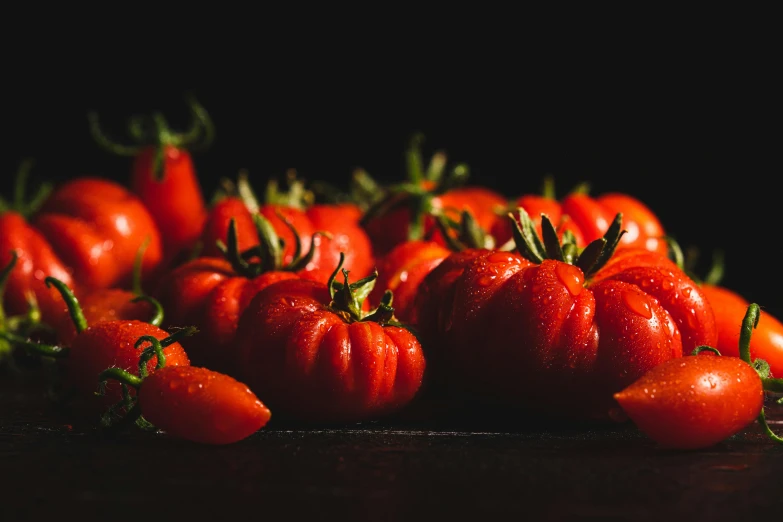 a pile of ripe tomatoes sitting on top of a wooden table