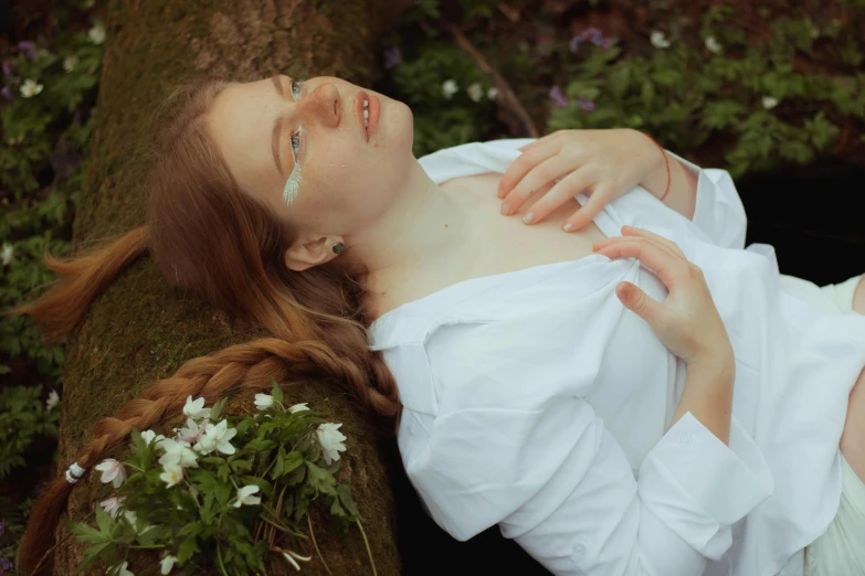 a woman is laying on the ground in the grass