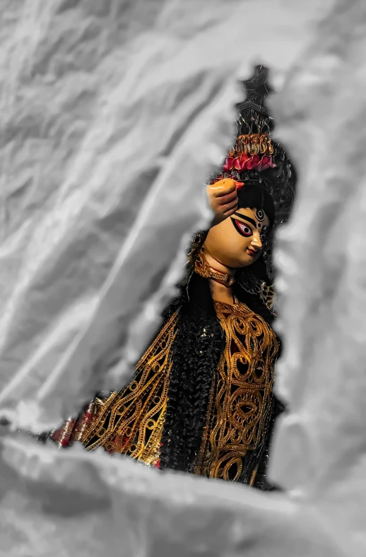 a colorful doll sitting on top of a snow covered hillside