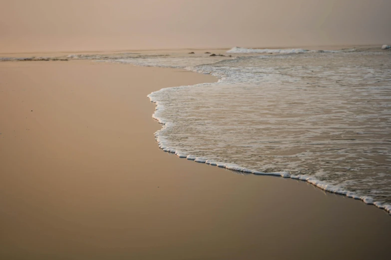 the water is wavy and choppy as it passes the beach