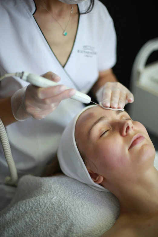 woman getting facial and head massage in a beauty salon