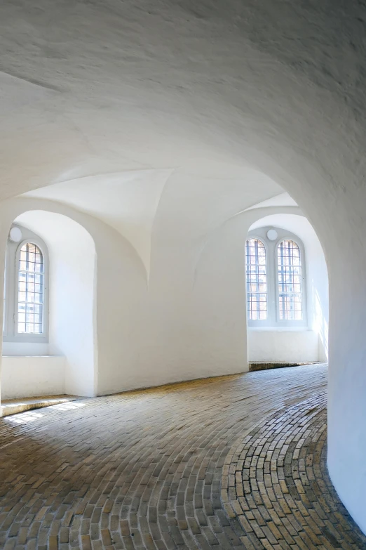 large white painted arched windows with cobblestone floor
