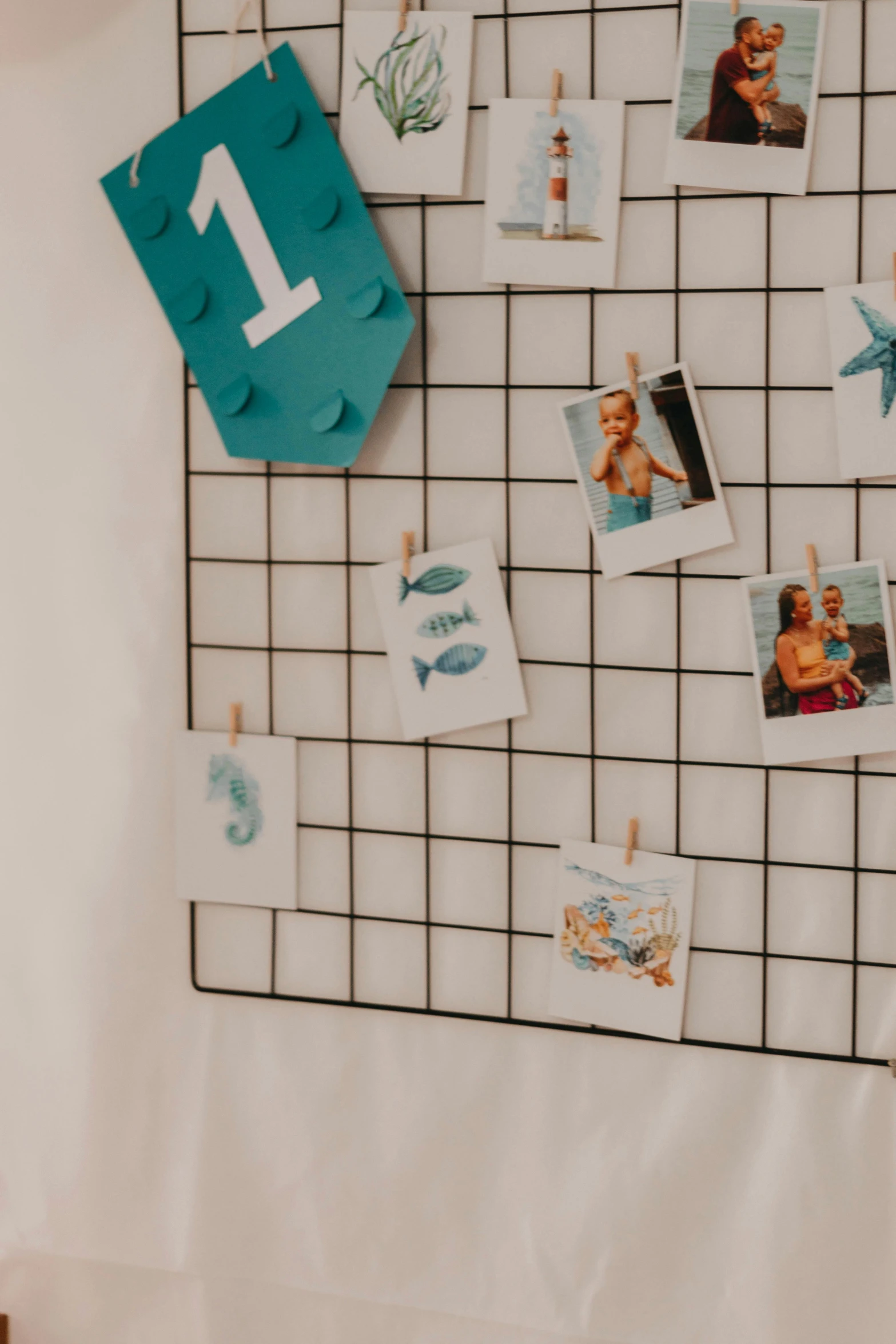 a white tile wall with several pictures and one number pinned to it