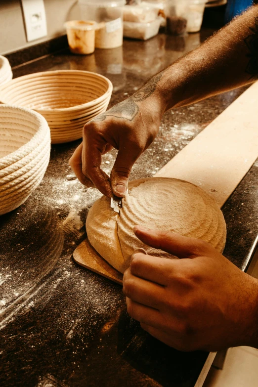 a person making round breads on the counter