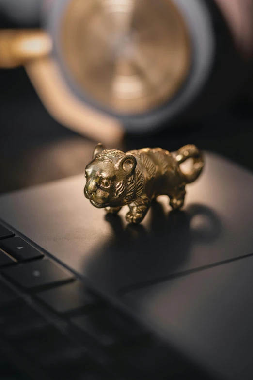 a small ss tiger sits on top of the laptop keyboard