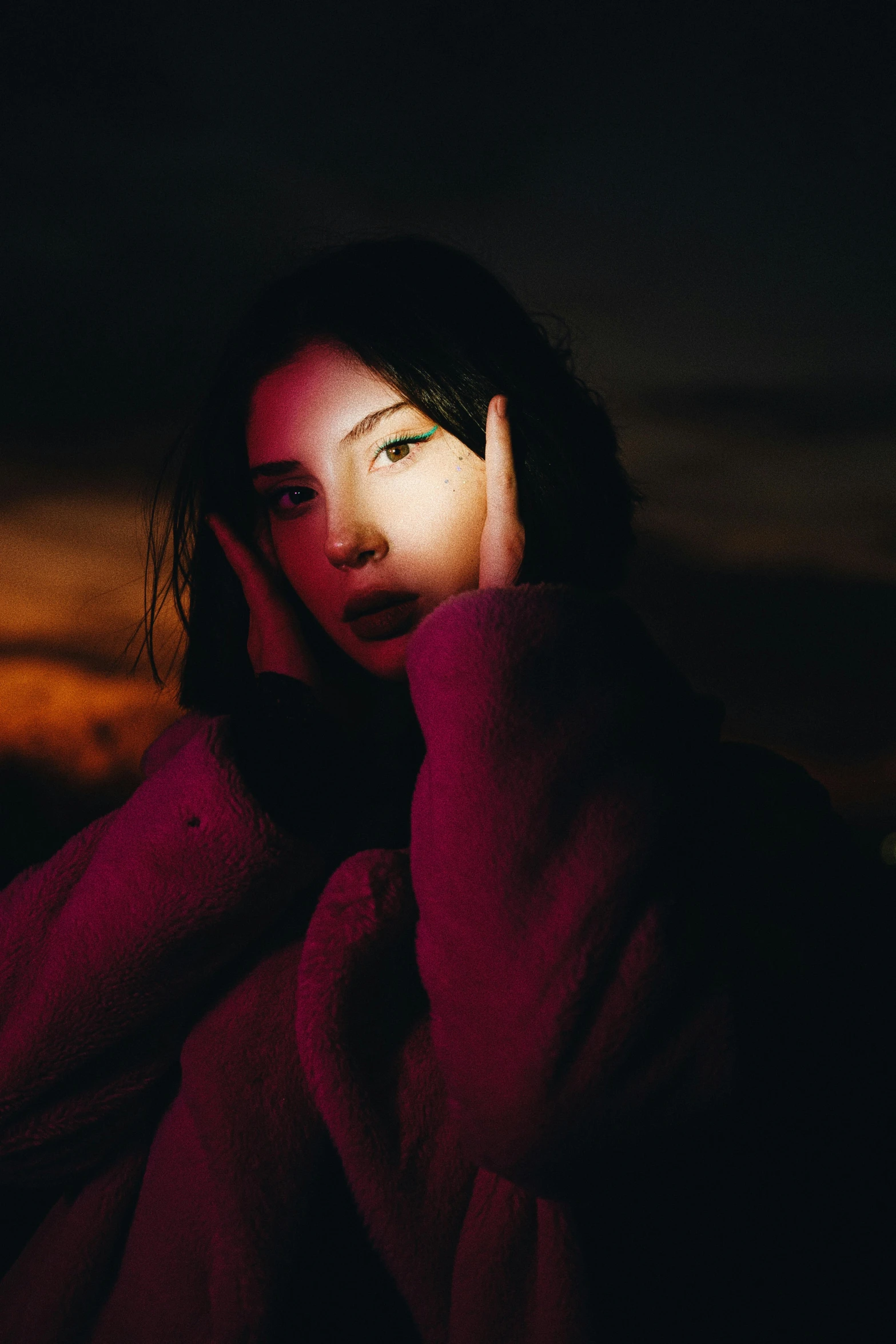 a woman looking up at the light of a street lamp