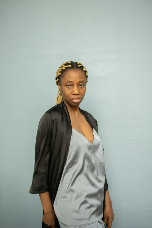 a woman stands with her arms folded in front of the camera