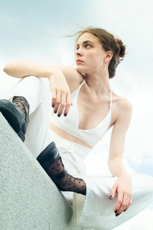 woman sitting down on top of rock and looking into distance