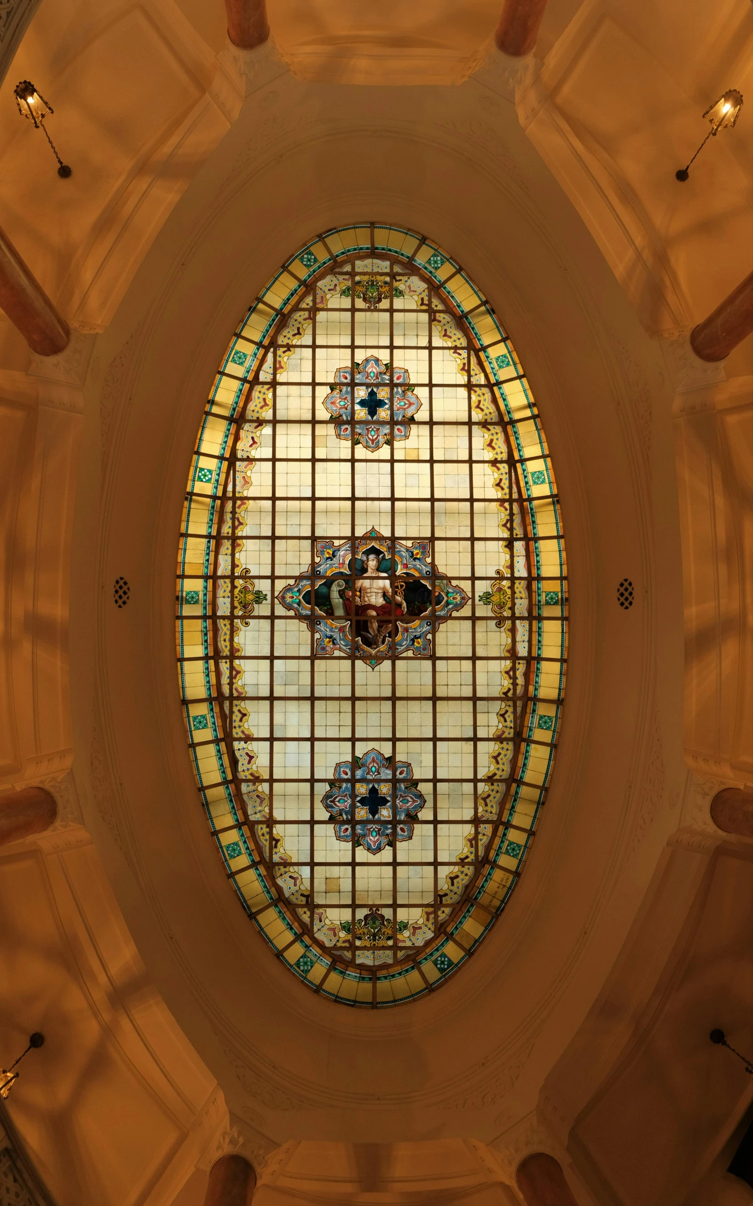 a large round glass window with columns on the ceiling