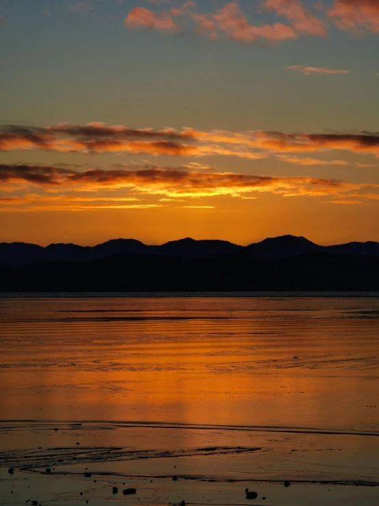 a boat floating on the sea at sunset