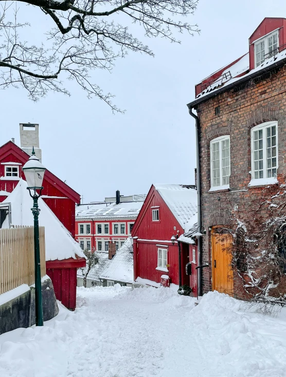 a snow covered street with several buildings behind it