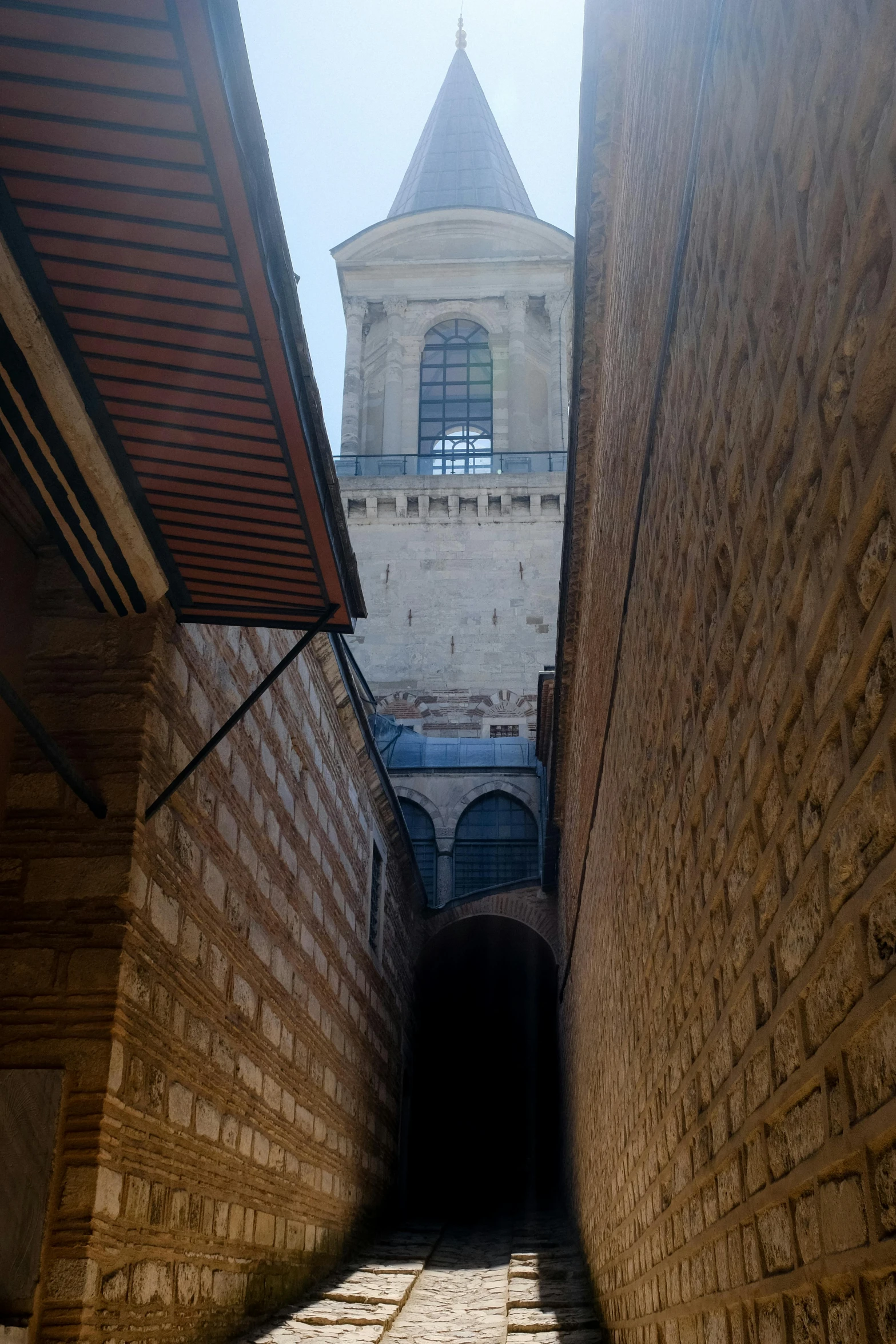 an old brick alley with a clock tower in the background