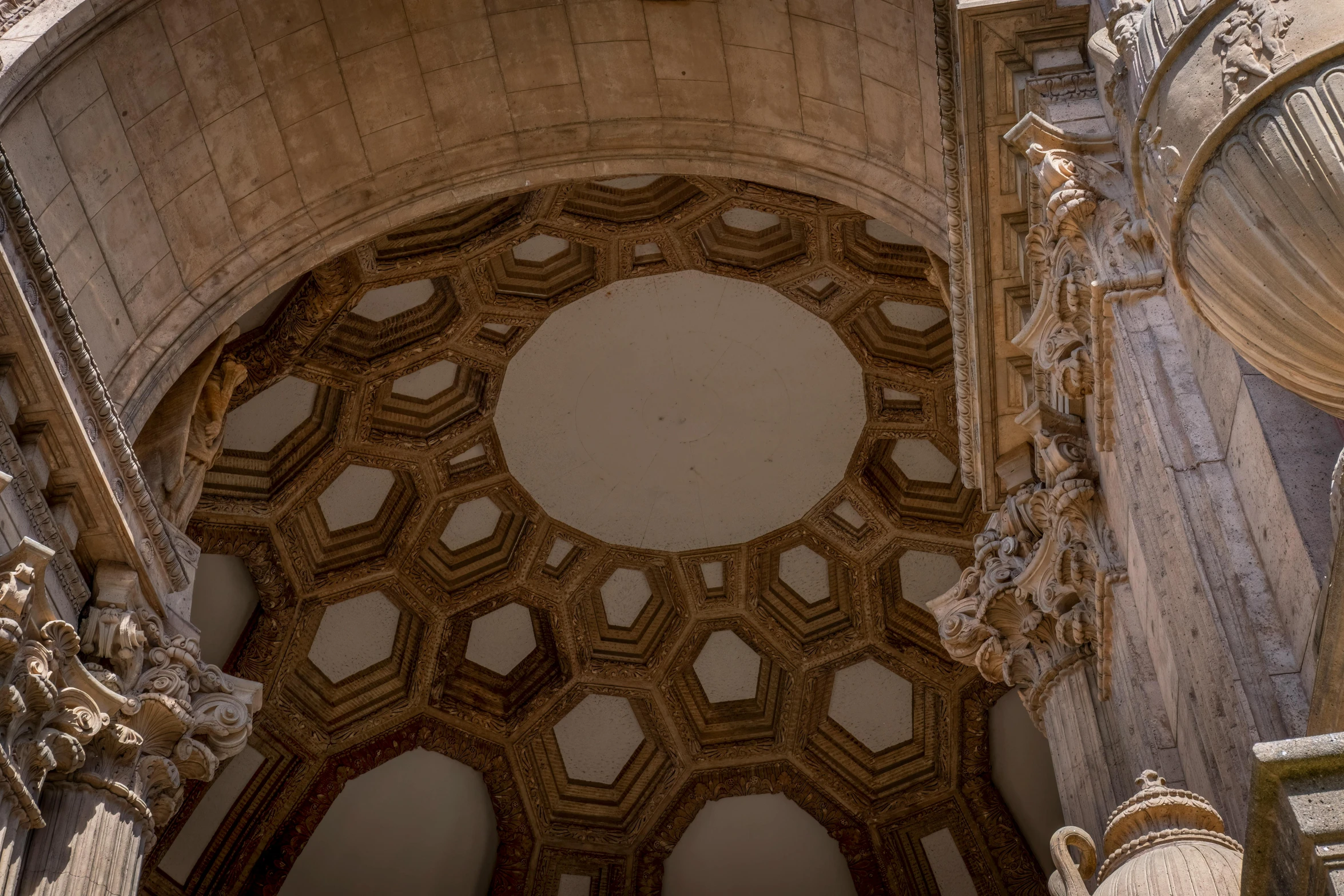 a po looking up into an arch that has a clock on it