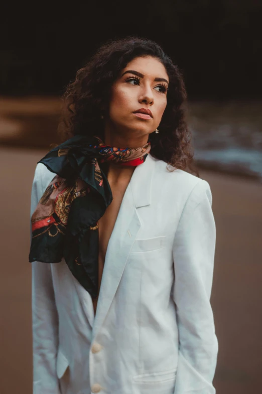 a woman wearing white suit and a scarf on a street