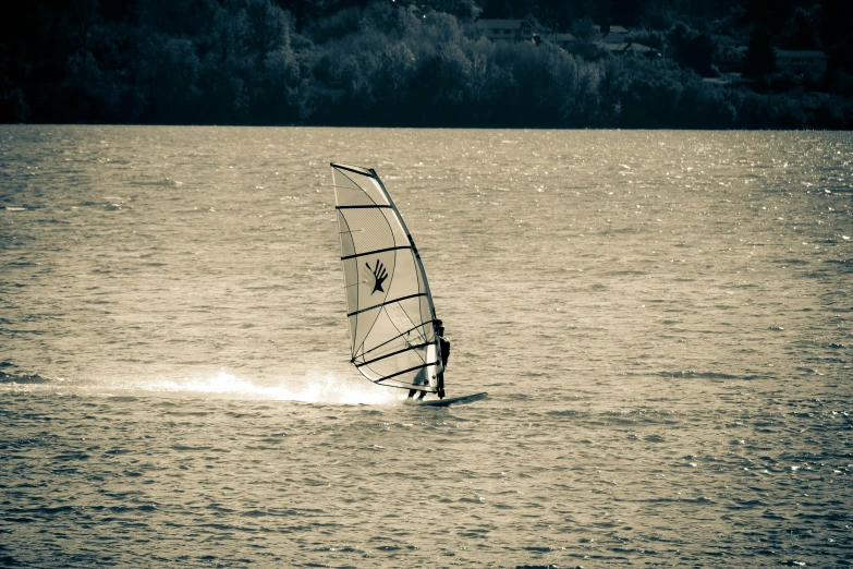 an adult para sailing on top of a lake in the sun