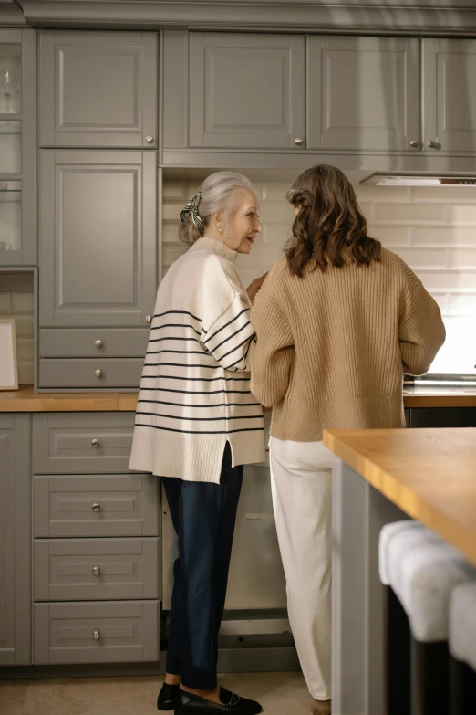 two elderly women in the kitchen talking