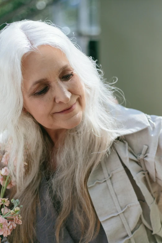 woman with white hair and gray shirt smiling