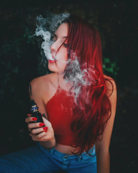 a woman smoking soing out of her hand next to trees