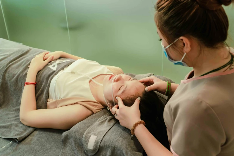 a person getting their forehead checked by an instructor