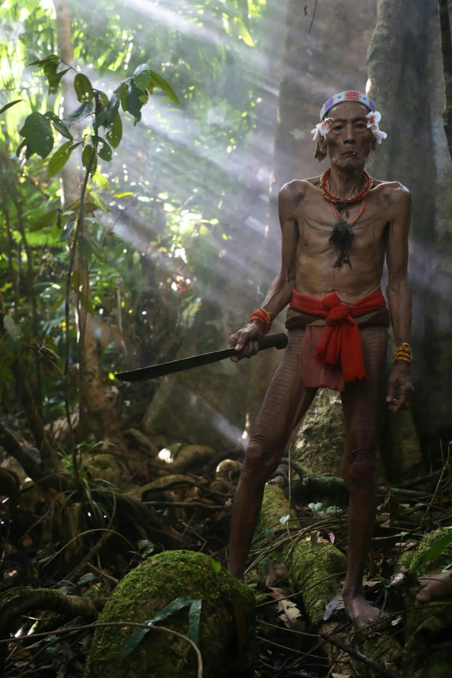 a native american man with a sword poses for a picture