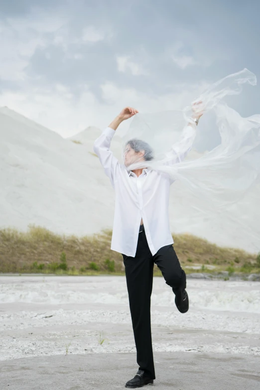 a woman in black pants and white shirt dancing outside