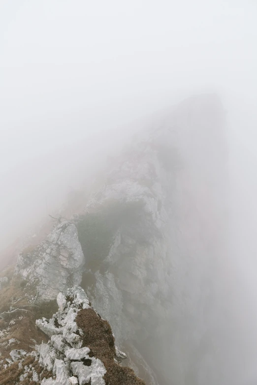 a couple standing on top of a mountain covered in snow