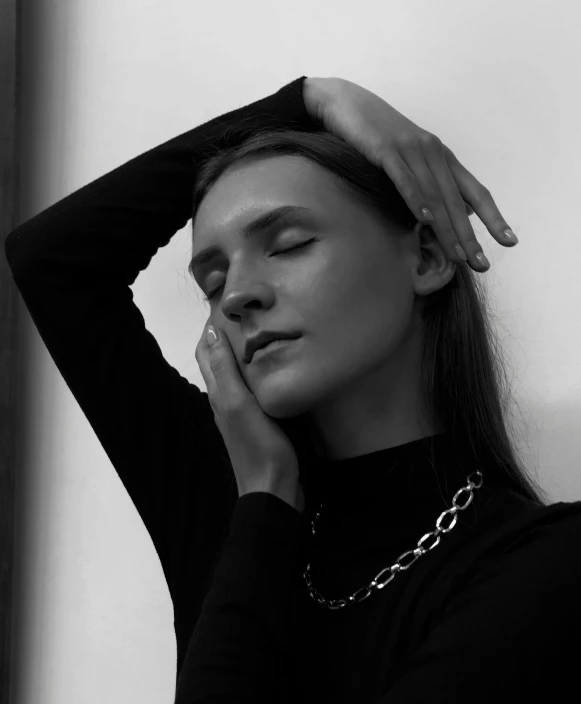 a young woman is wearing a black top and a silver necklace