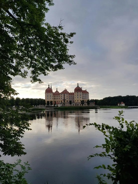 the large mansion in front of the water looks as if it is a fairy tale