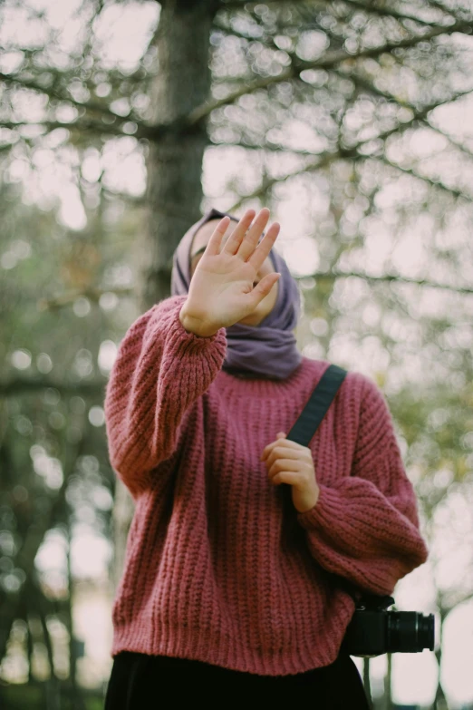 a young woman looking up while holding her hands up