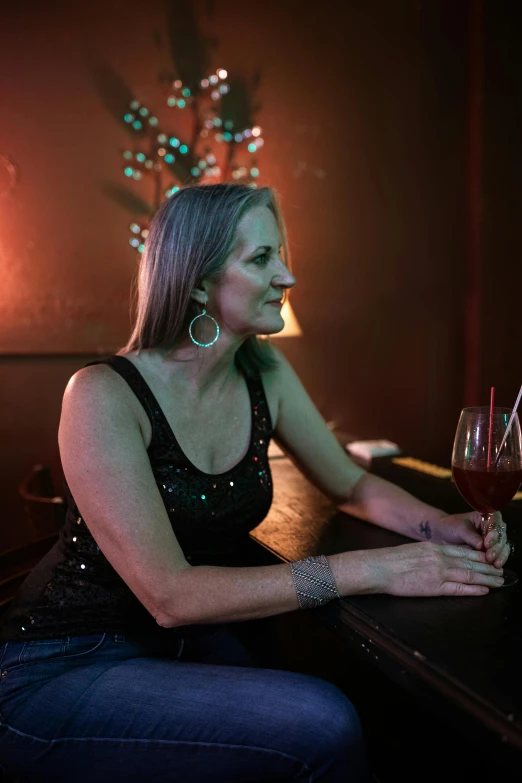 a woman sitting at a table with some wine glasses in front of her