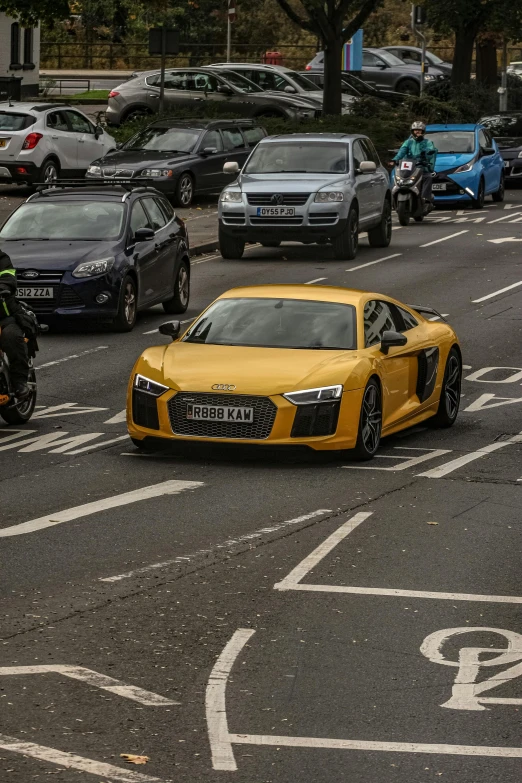 a yellow sports car driving down a street next to parking meters