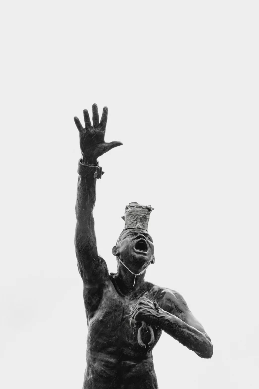 black and white pograph of a statue of a person reaching for a frisbee