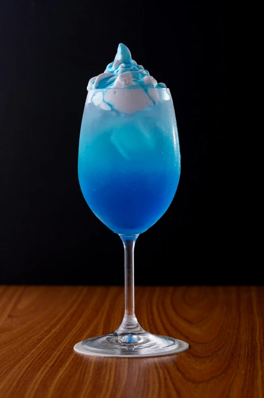 a blue beverage on the table with a blue cream topping