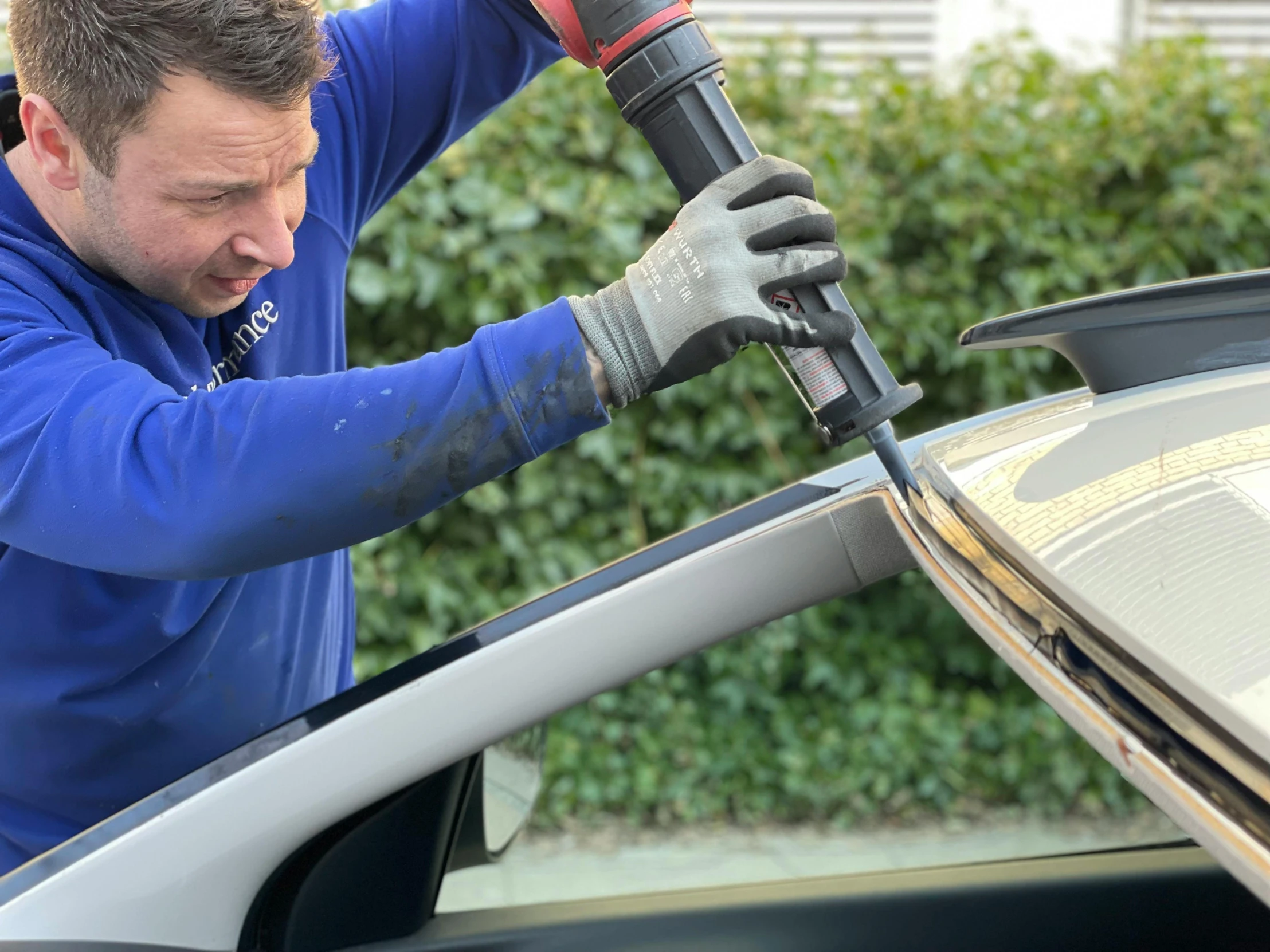 a man is removing a car with a power drill