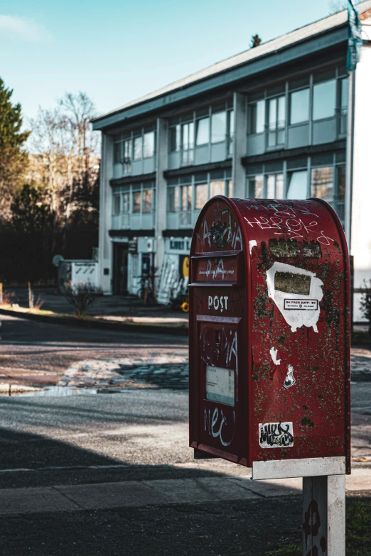 a red mailbox stands outside an office building