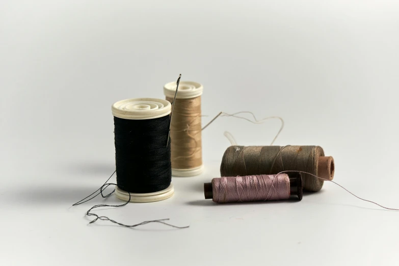 two spools of thread sitting on top of some sort of needles