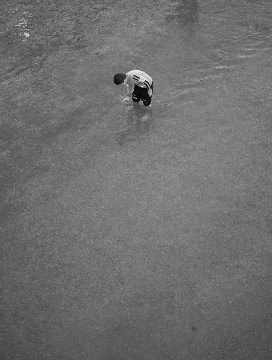 the man stands in water with his hat on