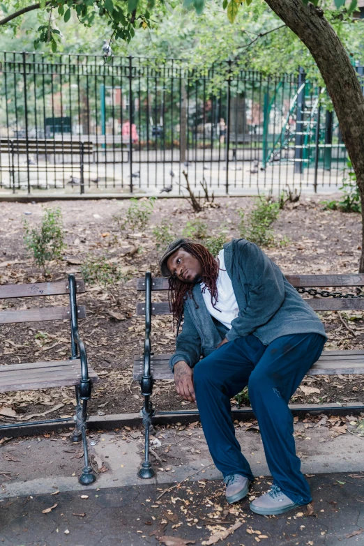 a man with long hair sits on a bench